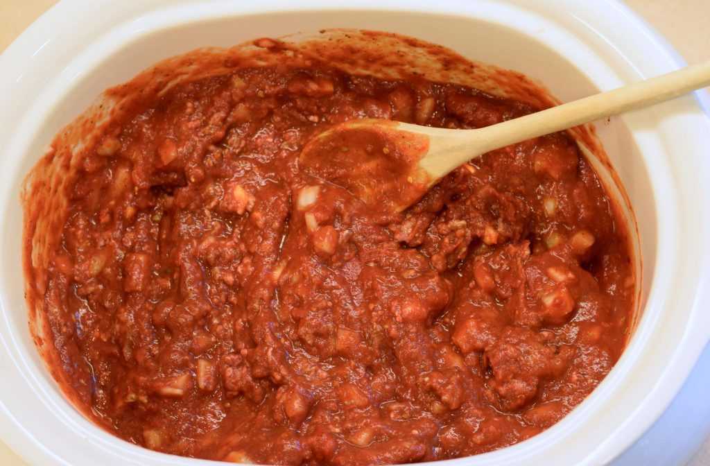 Spaghetti sauce with wooden spoon in a slow cooker