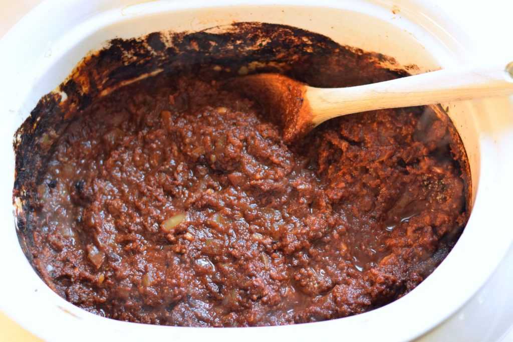 Spaghetti sauce with a wooden spoon in a slow cooker