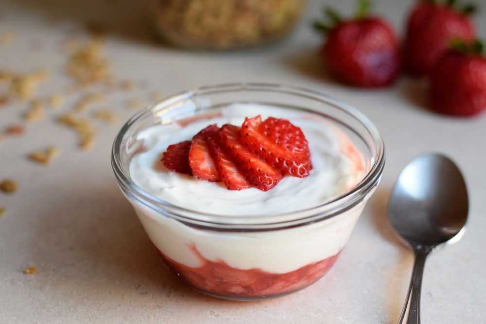 Yogurt in a bowl with strawberries and granola