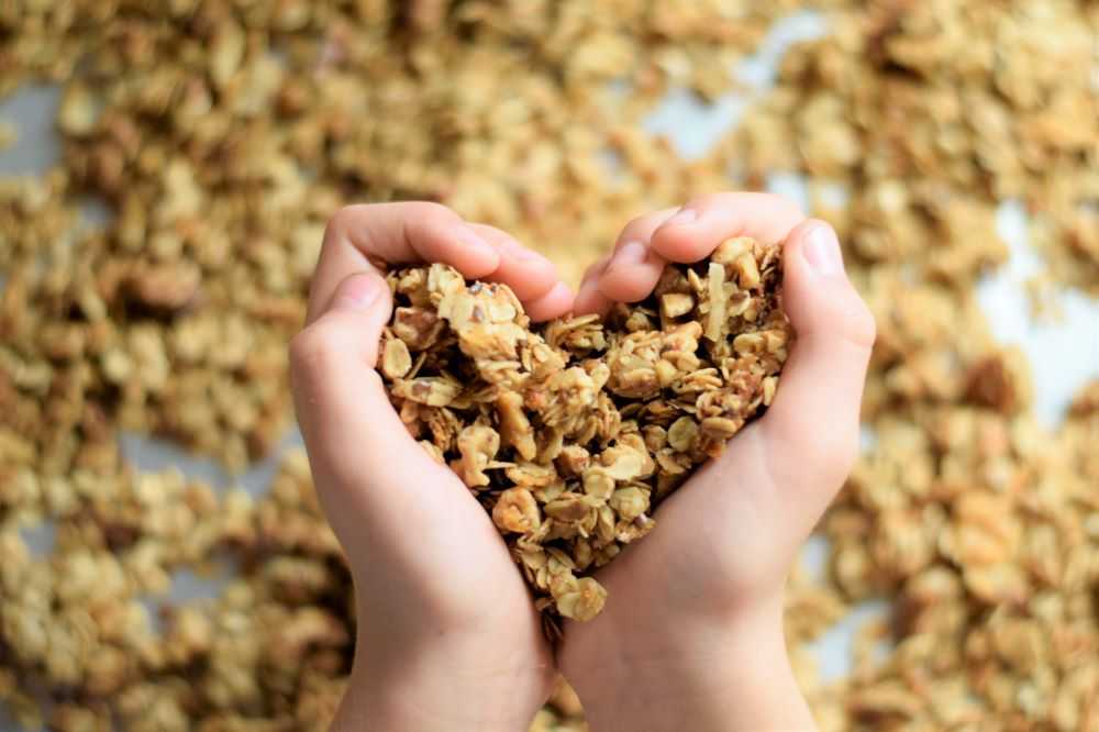 Granola held in hands in the shape of a heart