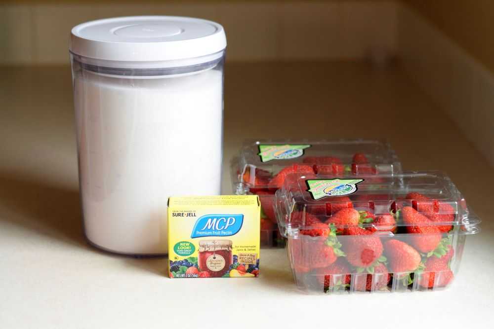 Ingredients for freezer jam: sugar, pectin, and strawberries.