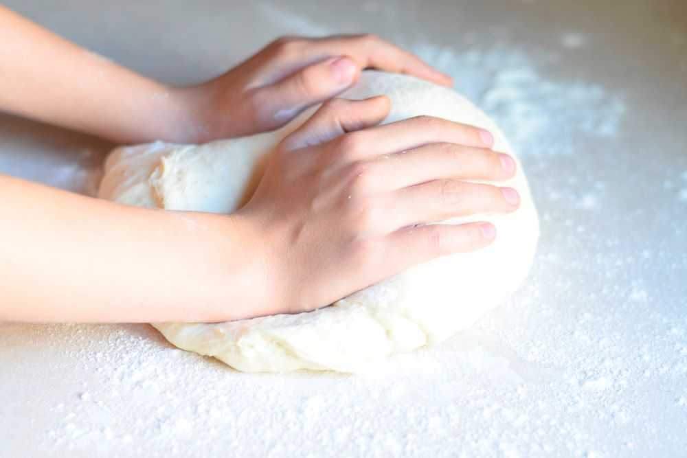 Knead the dough for soft garlic breadsticks