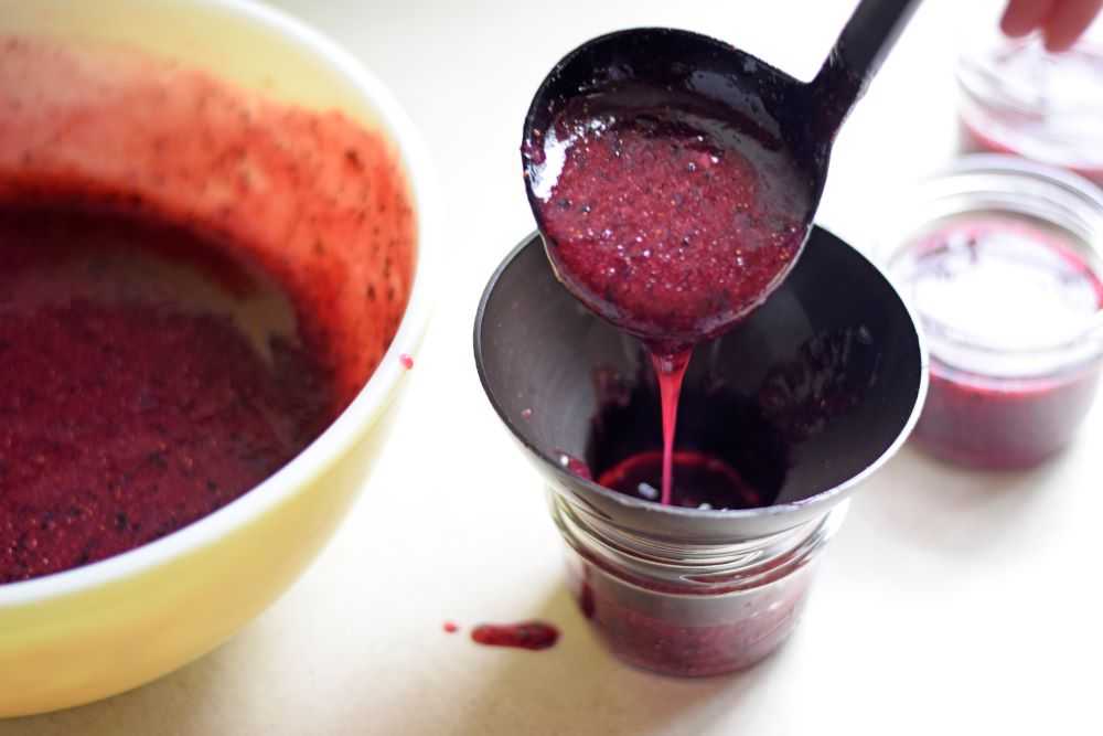 filling jars with blueberry freezer jam